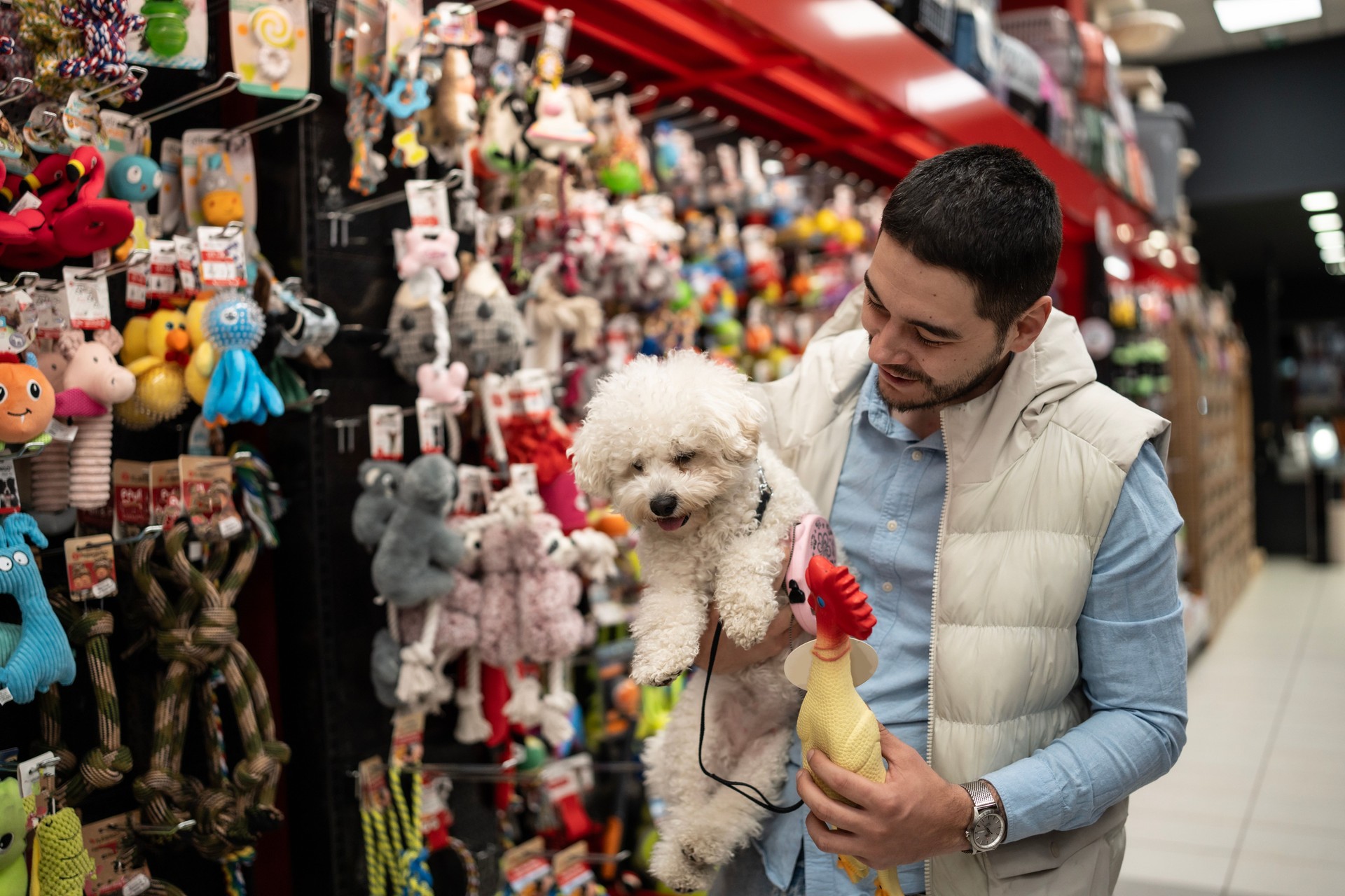 Man Shopping for Toys With His Dog in a Pet Store